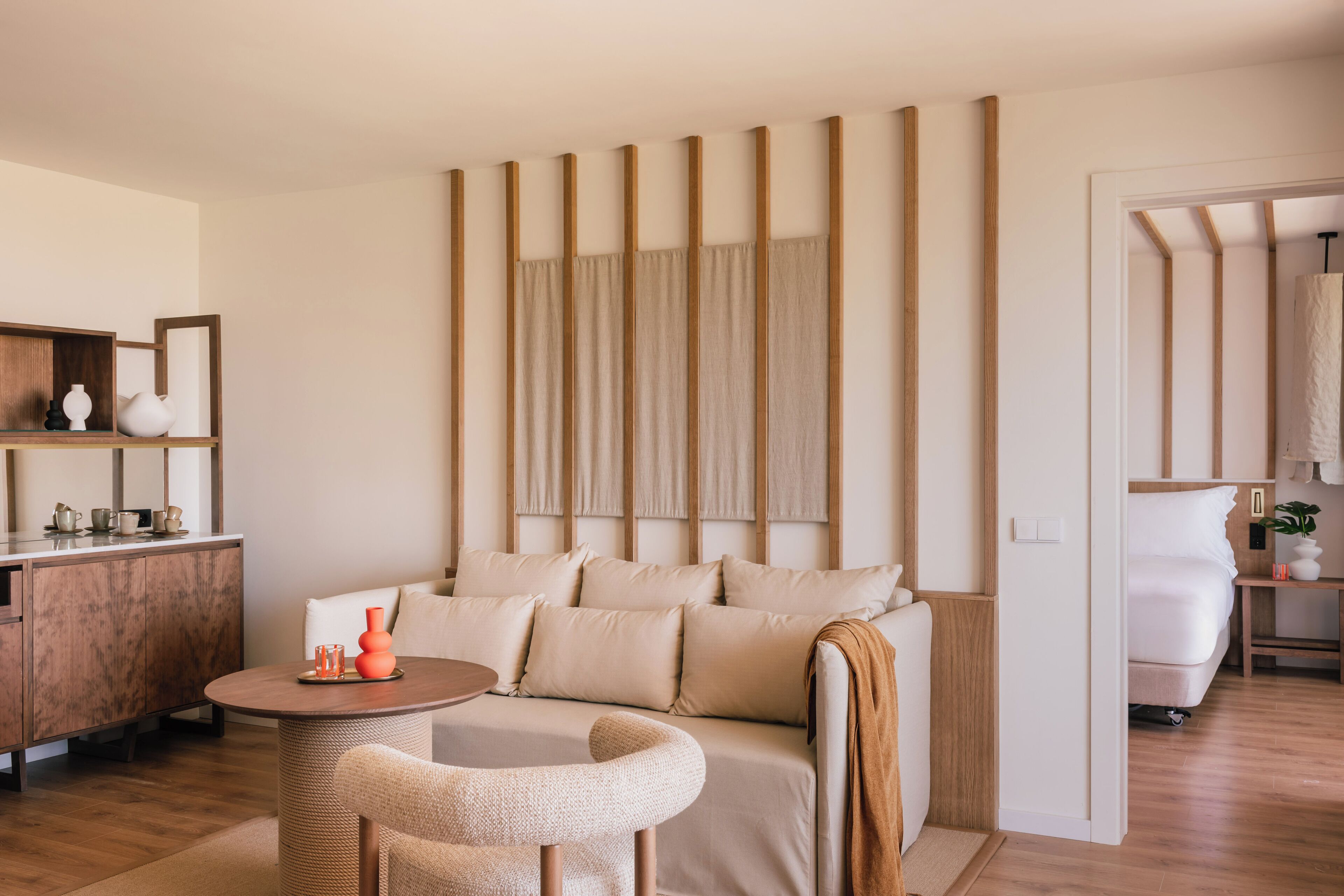 Una sala de estar moderna con un sofá, una mesa redonda y un mueble de madera.