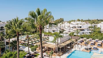 A resort with multiple pools, palm trees, and white buildings.