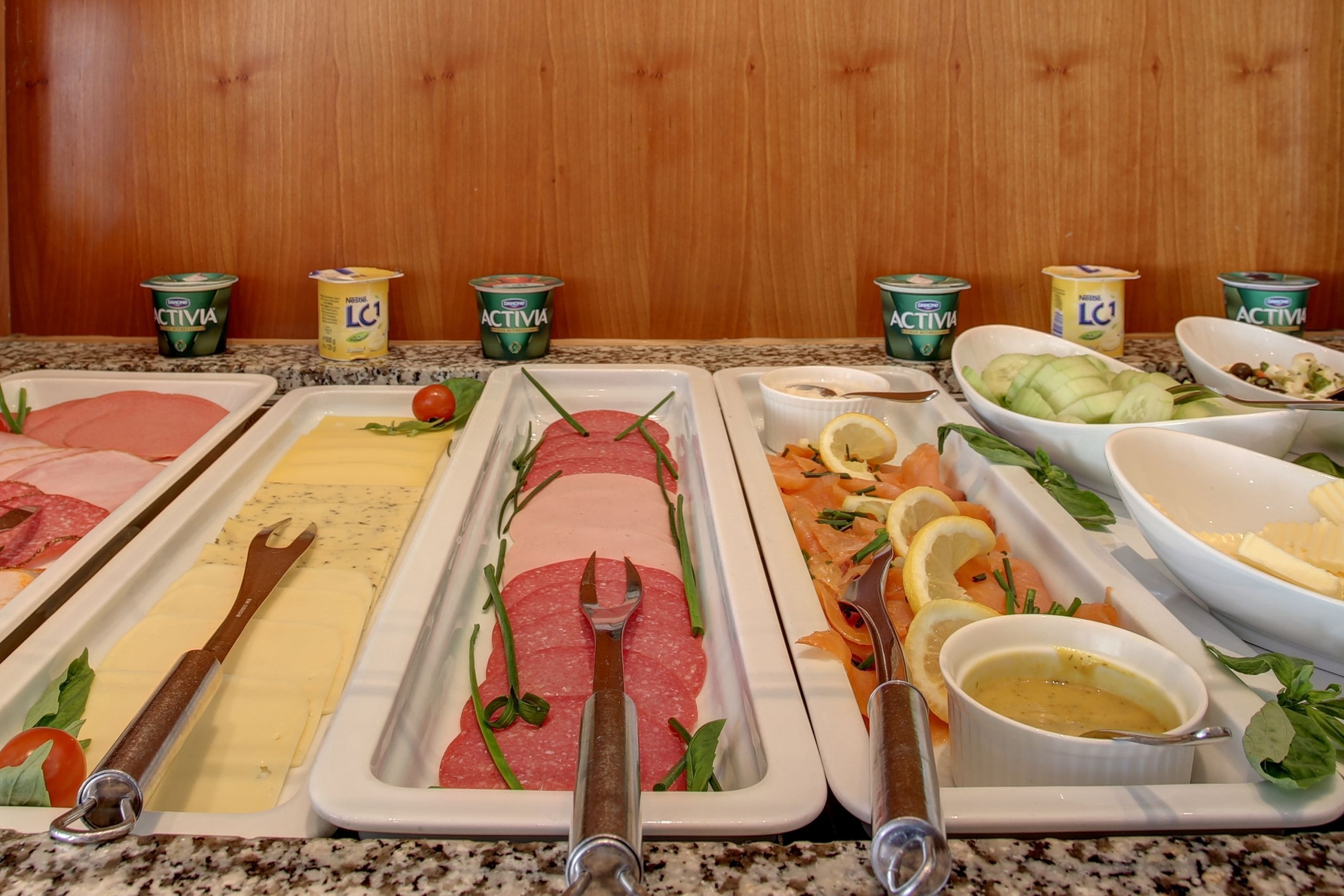 A buffet with various food options including meats, cheeses, and salads, with condiments and drinks available.
