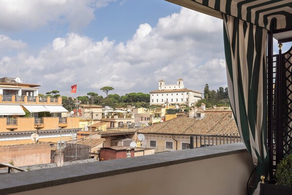Un balcon offrant une vue sur le paysage urbain, avec des bâtiments et un drapeau.
