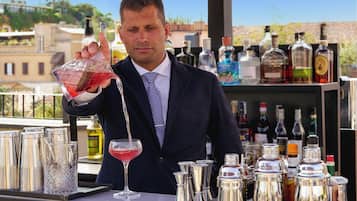 A bartender pouring a drink into a glass.