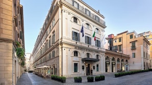 A historic building with a classic facade, multiple balconies, and flags. - Hotel d'Inghilterra Roma - Starhotels Collezione (Rome)