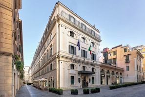 A historic building with a classic facade, multiple balconies, and flags. - Hotel d'Inghilterra Roma - Starhotels Collezione (Rome)