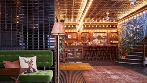 A bar area with a green couch, red chairs, and a patterned rug. - Max Brown Hotel Midtown, part of Sircle Collection (Düsseldorf)
