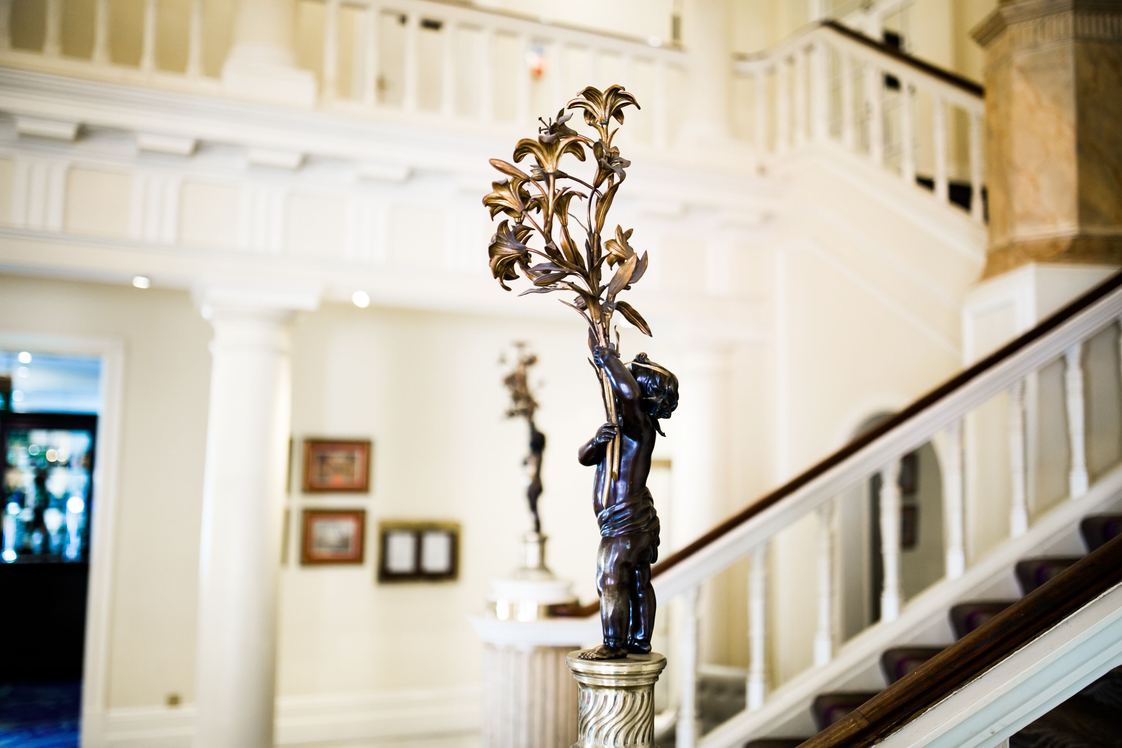 A grand staircase with a decorative metal sculpture on the balustrade.