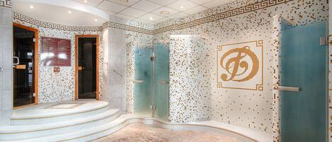 A modern bathroom with a mosaic tile design, a freestanding bathtub, and a glass-enclosed shower area.