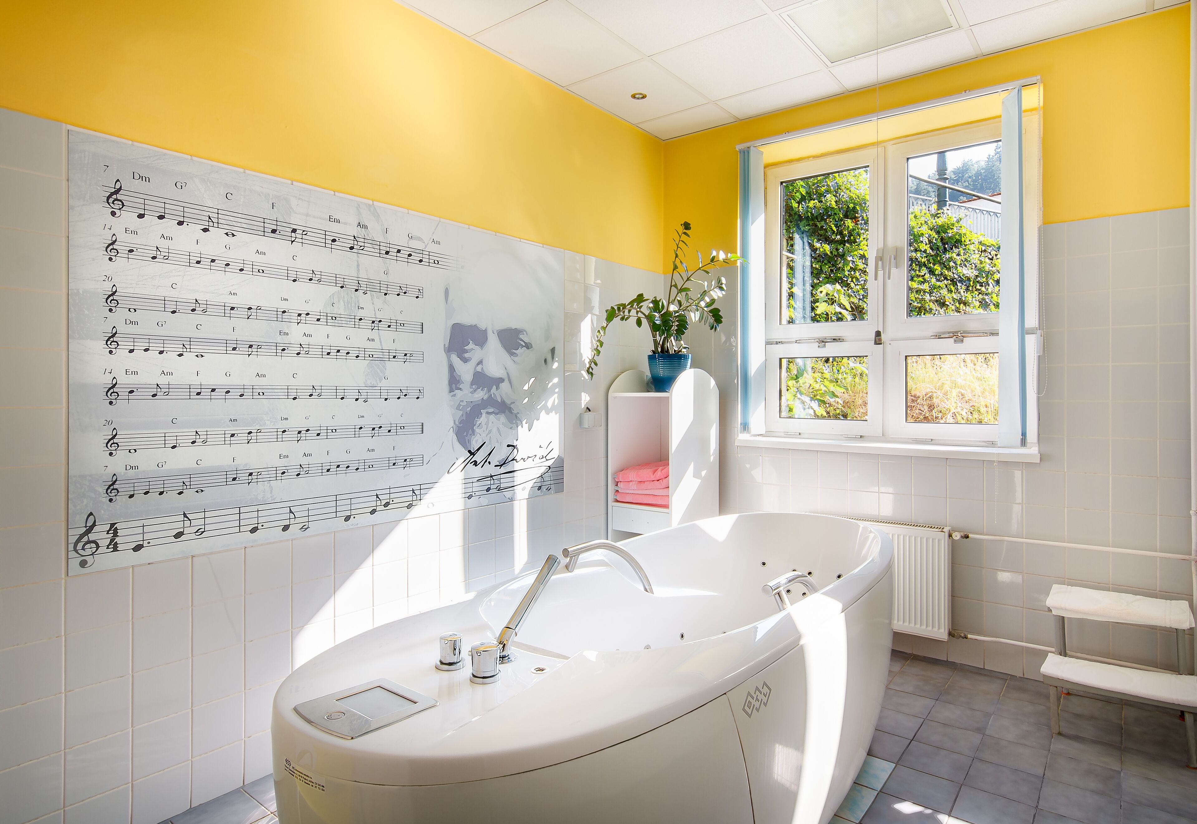 Une salle de bain avec une grande fenêtre, une baignoire et un mur orné de partitions musicales.