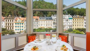 A dining table set with plates, glasses, and cutlery, overlooking a cityscape with historic buildings. - Dvorak Spa & Wellness (Karlovy Vary)