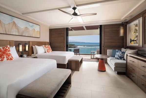A hotel room with two beds, a sofa, a small table, and a balcony with a view of the ocean. - Mauna Kea Beach Hotel, Autograph Collection (Kamuela)