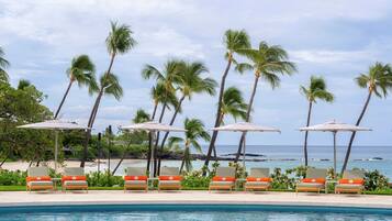 Alberca al aire libre, sombrillas en la alberca y camastros