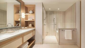 Une salle de bain moderne avec un meuble-lavabo en bois, un grand miroir, un espace douche et un porte-serviettes.