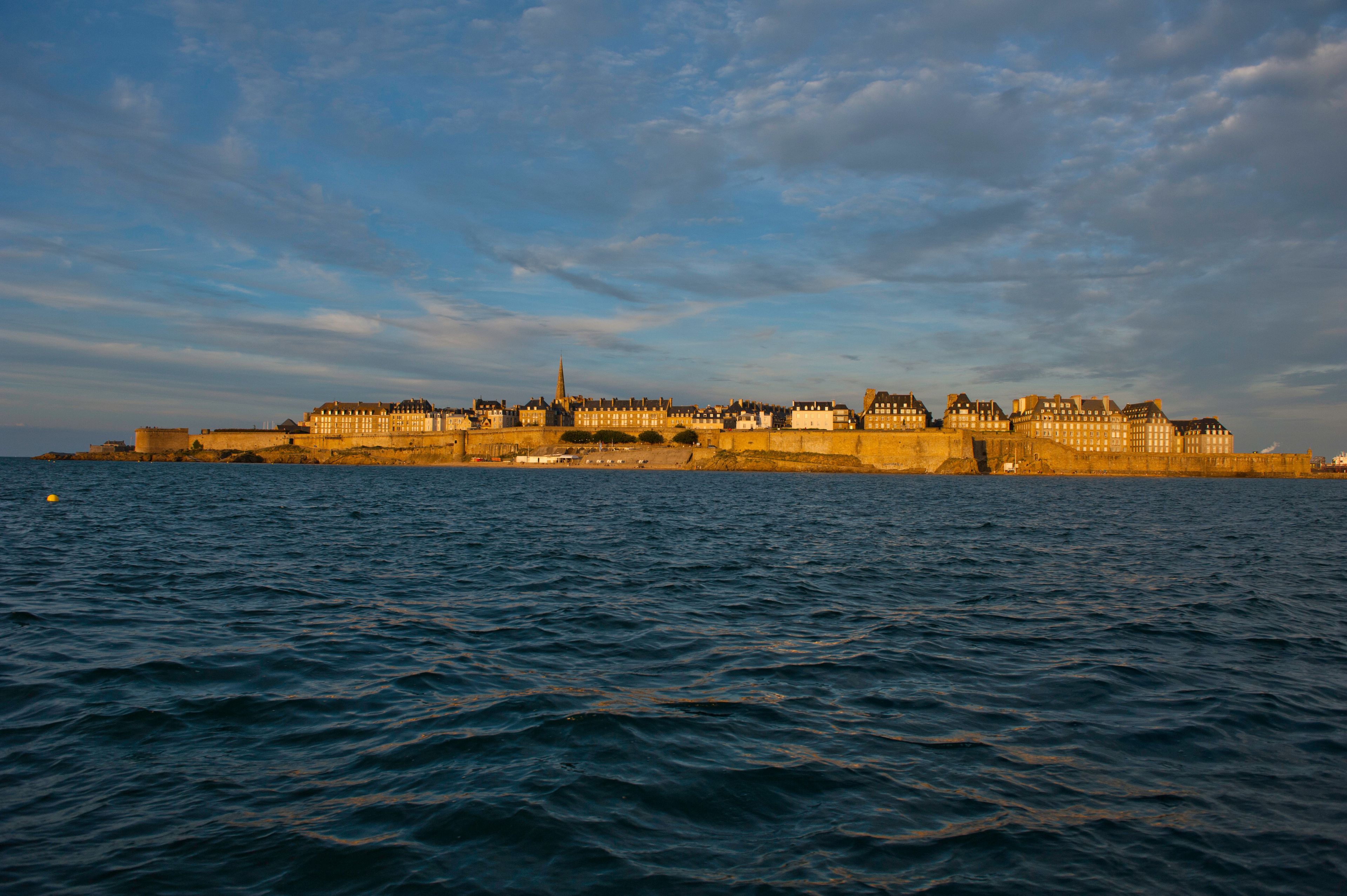 A coastal cityscape with historic buildings along the waterfront.
