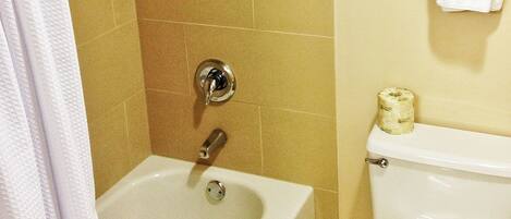 A bathroom with a bathtub, toilet, and towel rack.