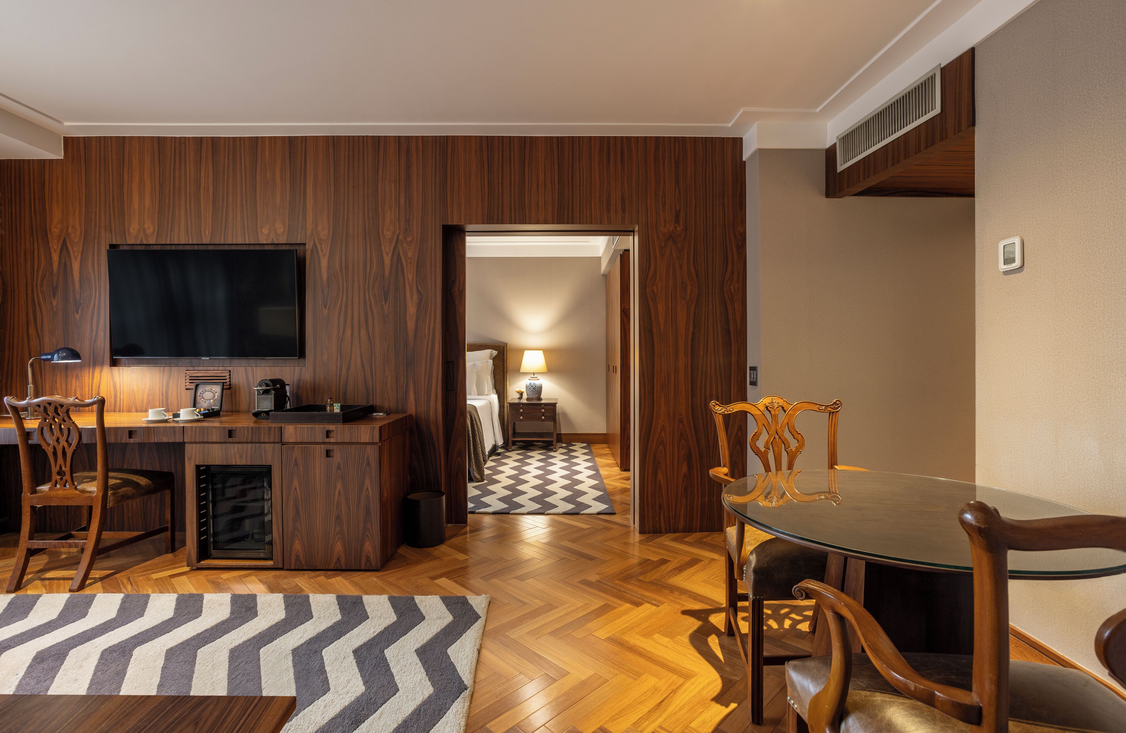 A modern kitchen with a flat-screen TV, wooden cabinetry, and a built-in oven.