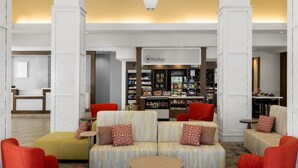 A spacious lobby with a central seating area, a bar, and a view of the bar area. - Hilton Garden Inn Pascagoula (Pascagoula)