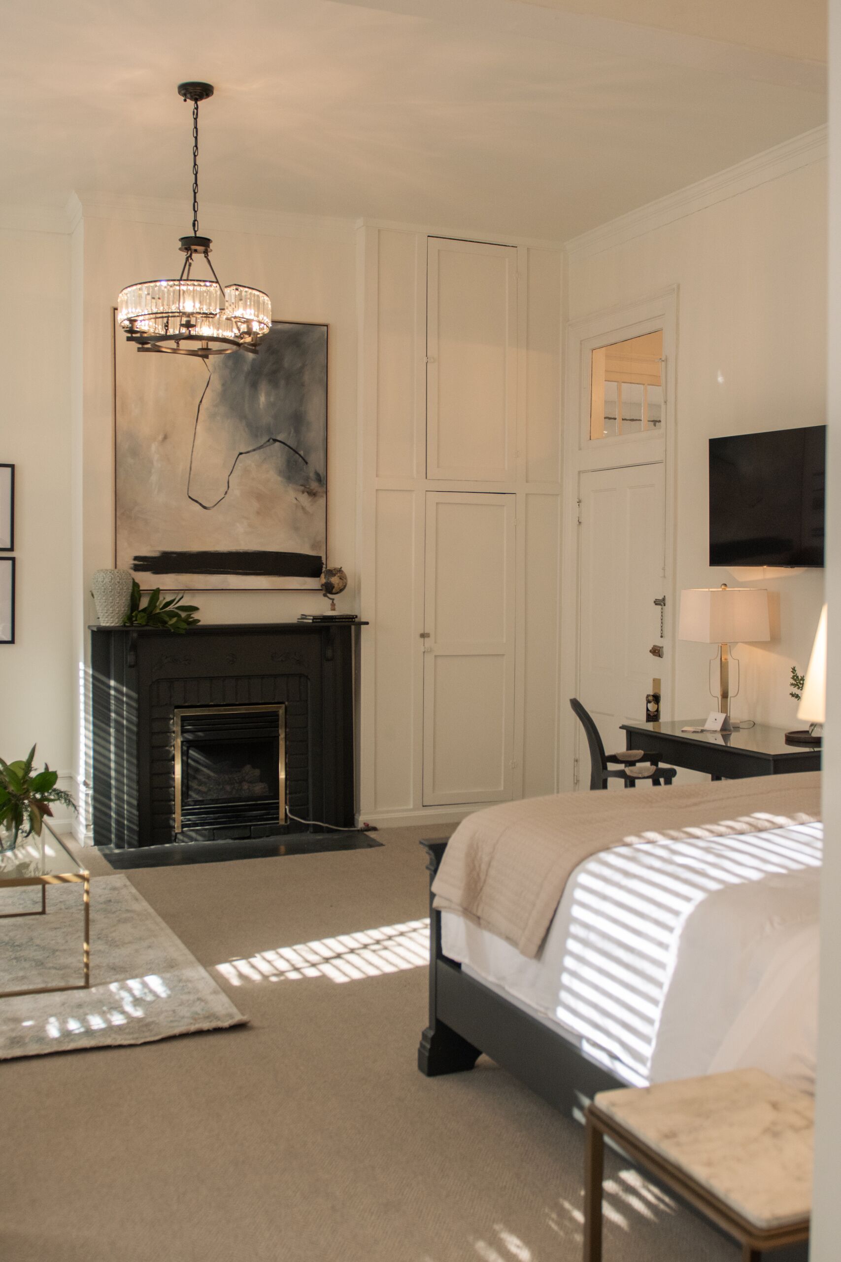 Une chambre à coucher avec une cheminée, un lit, un bureau et un téléviseur.