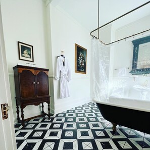 A bathroom with a bathtub, a wooden cabinet, and patterned floor tiles.