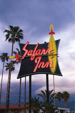 A sign for Safari Inn with a palm tree backdrop.