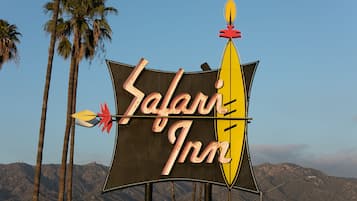 A sign for Safari Inn with a stylized safari theme, including a yellow boat and arrows.