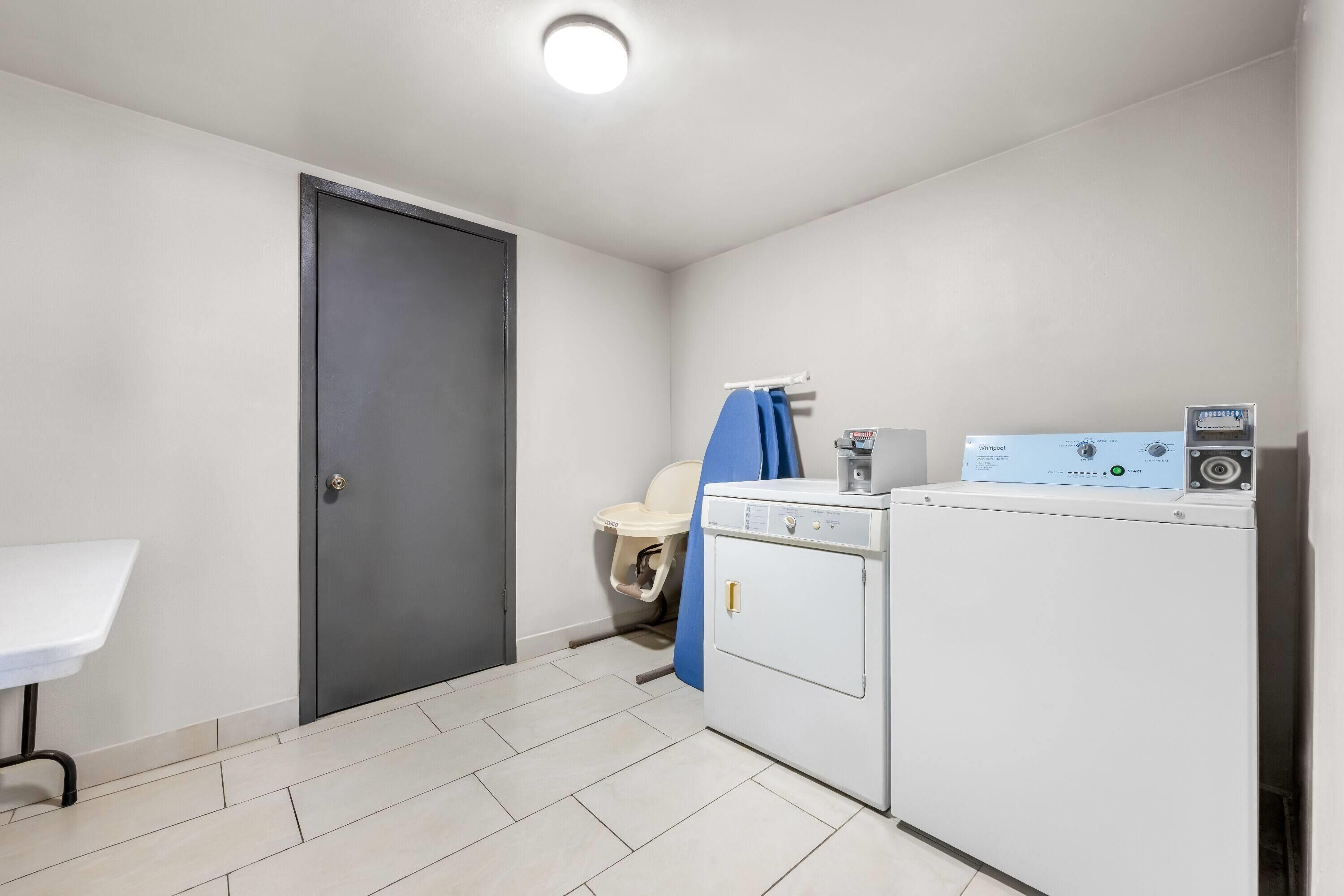 A laundry room with a washing machine, a dryer, and a door.