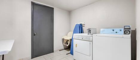 A laundry room with a washing machine, a dryer, and a door.