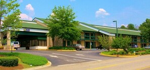 A building with a green roof, a parking lot, and a few cars. - Days Inn by Wyndham Hoover Birmingham (Birmingham)