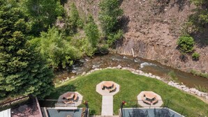 A deck with outdoor seating and a view of a river. - Deadwood Gulch Resort, Trademark Collection by Wyndham (Deadwood)