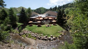 A lodge with outdoor seating and a view of a mountain. - Deadwood Gulch Resort, Trademark Collection by Wyndham (Deadwood)