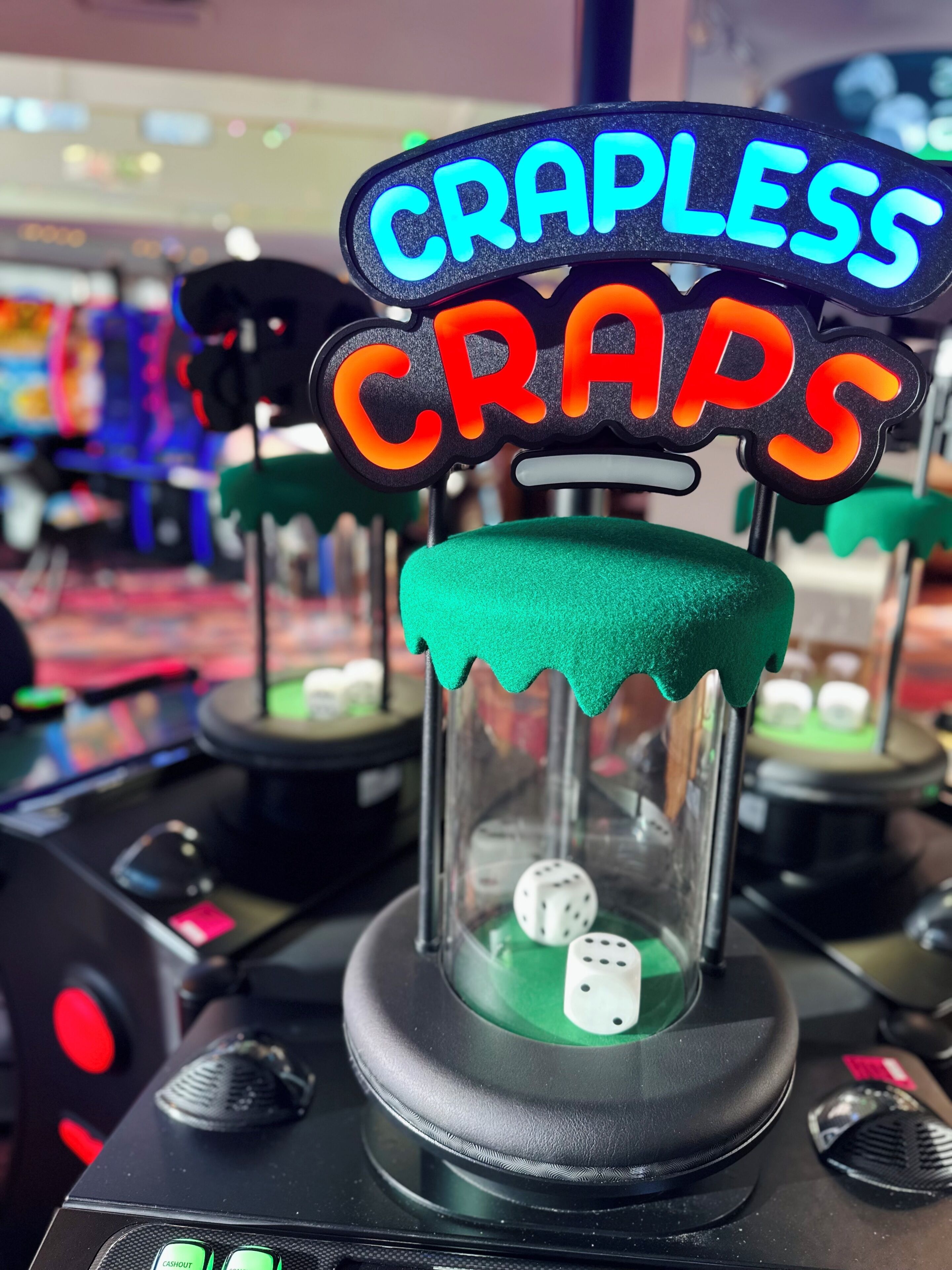 Een dobbelmachine voor craps met dobbelstenen en een neonbord waarop 'CRAPLESS CRAPS' staat.