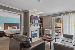 Relax by the fireplace with a large bed and comfortable sofa, enjoying a view of the outdoors.