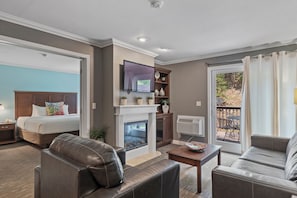 Relax by the fireplace with a large bed and comfortable sofa, enjoying a view of the outdoors.