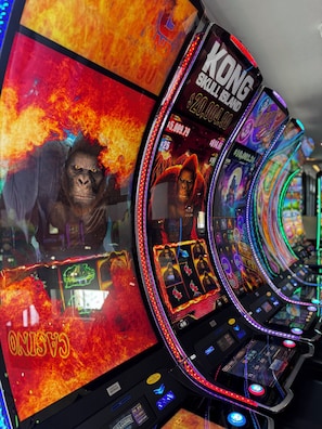 Ein Spielautomat mit dem Thema 'Kong: Skull Island', der einen Gorilla und einen Hintergrund mit Feuer zeigt.