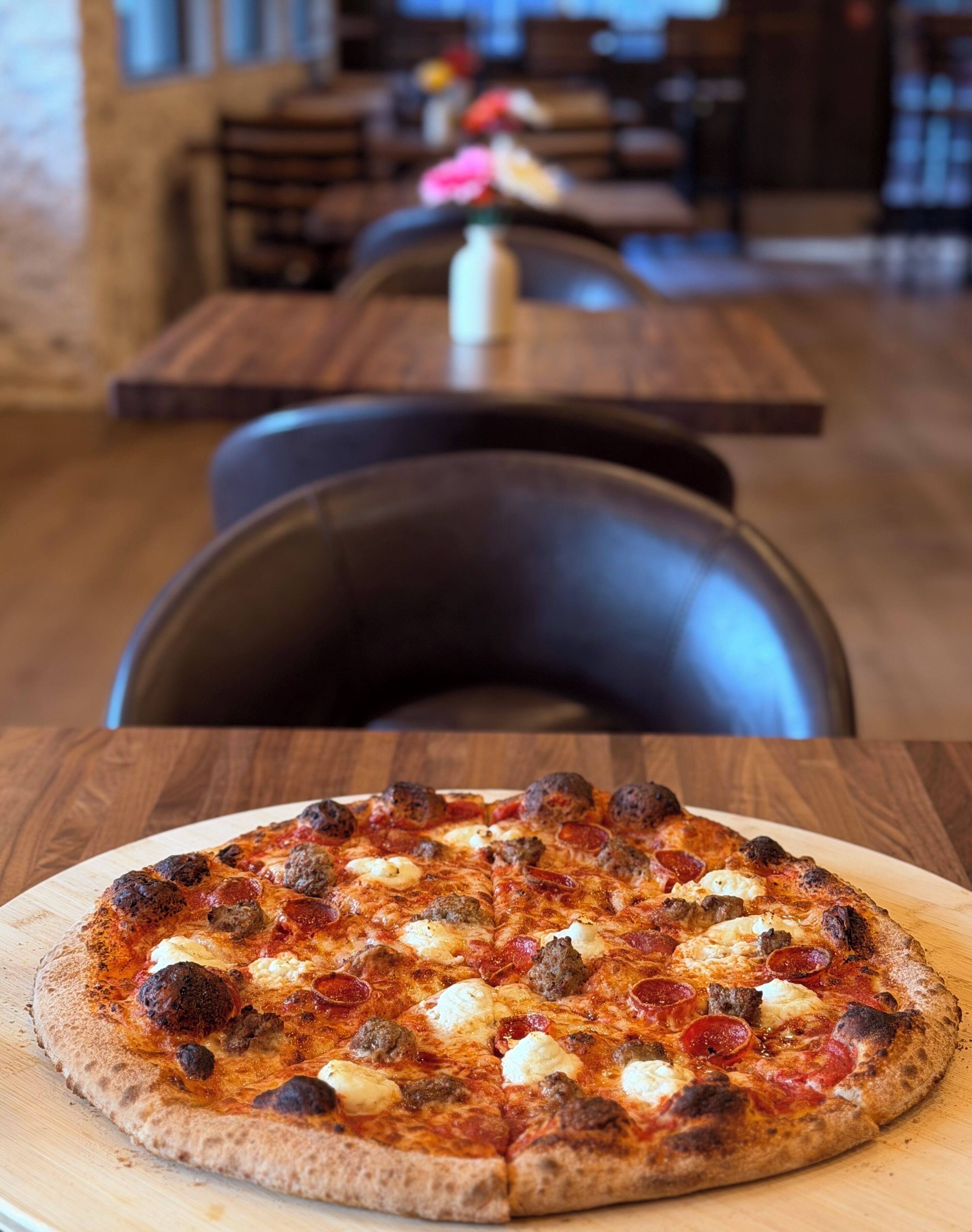 Uma pizza em uma tábua de madeira.