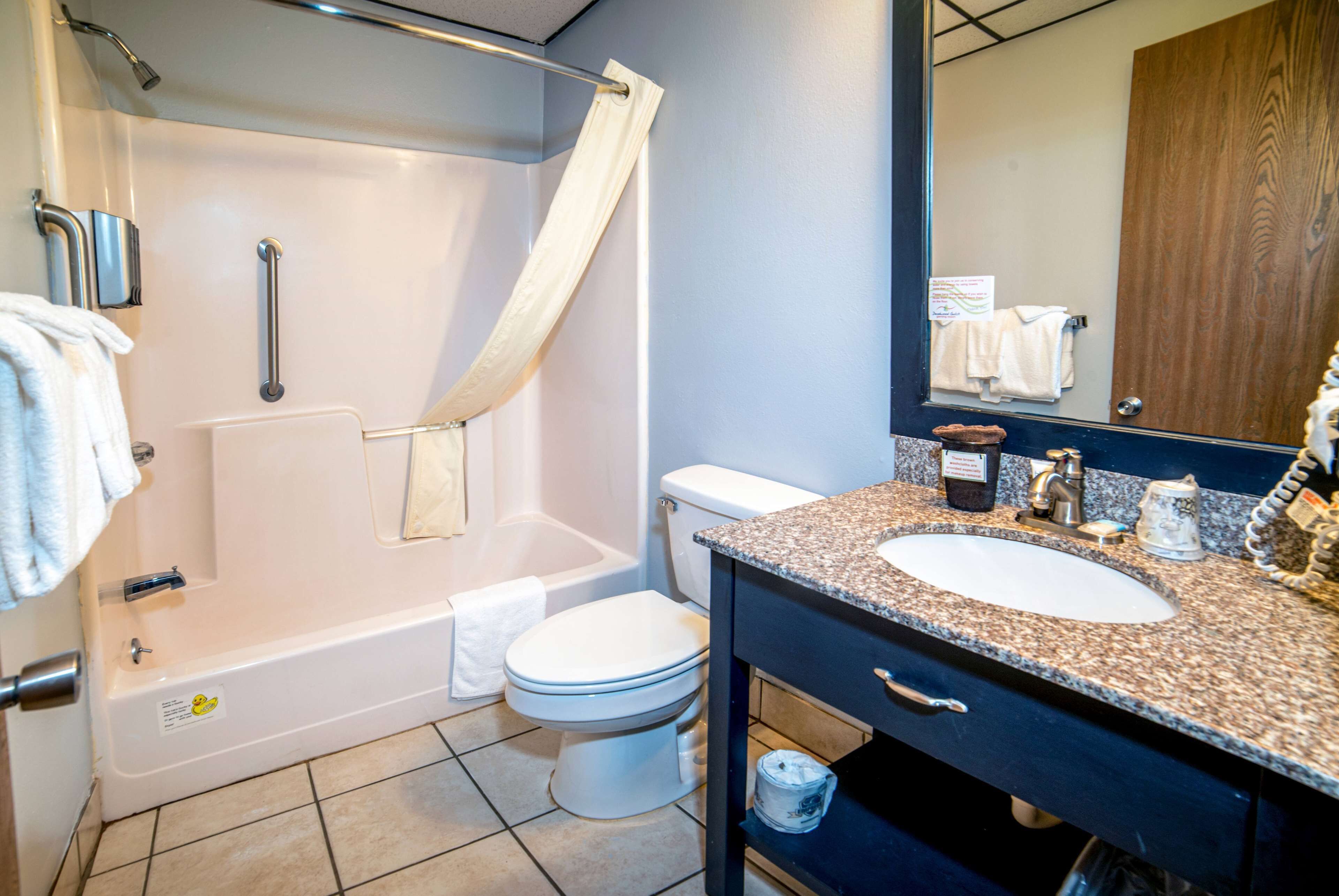 Ein Badezimmer mit Badewanne, Toilette, Waschbecken und Spiegel.