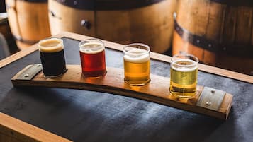 Cuatro vasos de cerveza sobre una bandeja de madera.