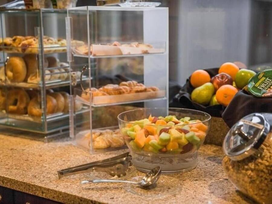 A breakfast buffet with various pastries and a fruit bowl.
