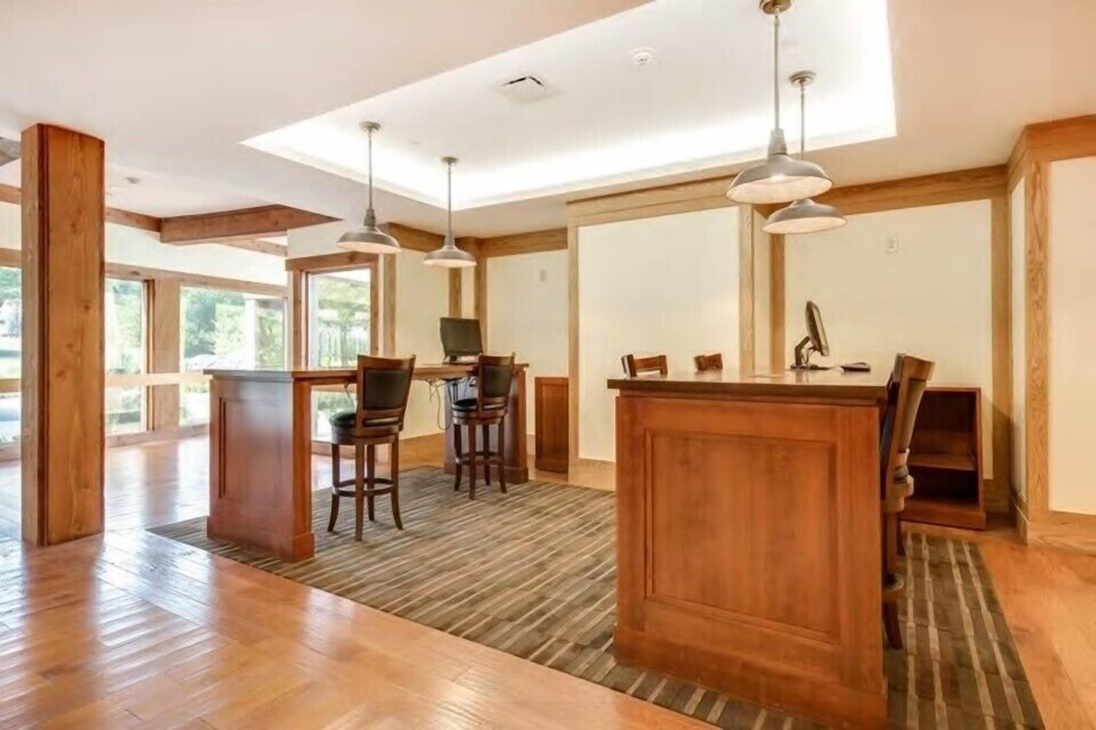 A spacious kitchen with wooden cabinetry, a central island, and pendant lighting.