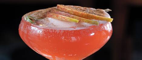A cocktail in a stemmed glass with a garnish on top.