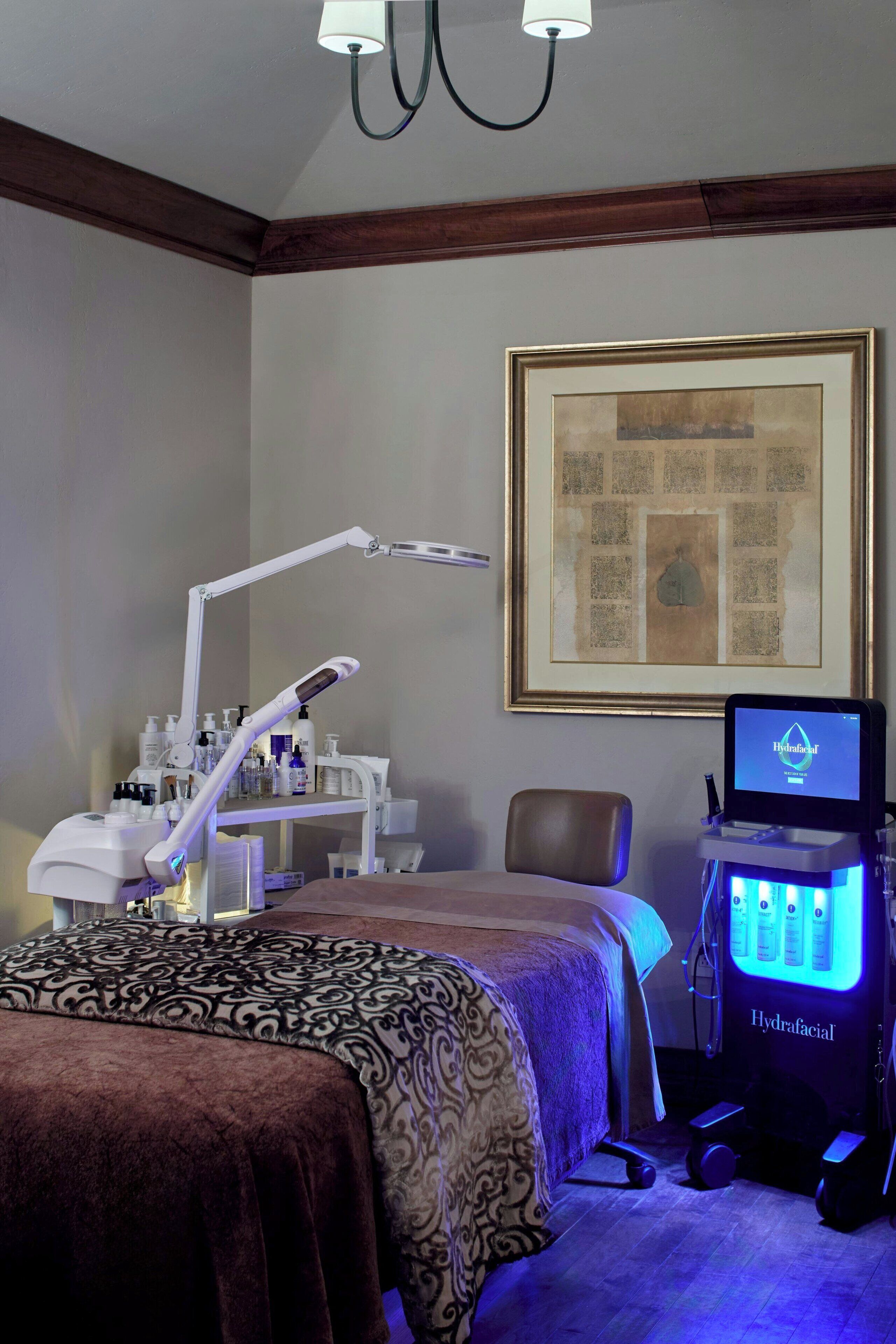 A room with a bed, a desk with a computer, a chair, and a framed picture on the wall.