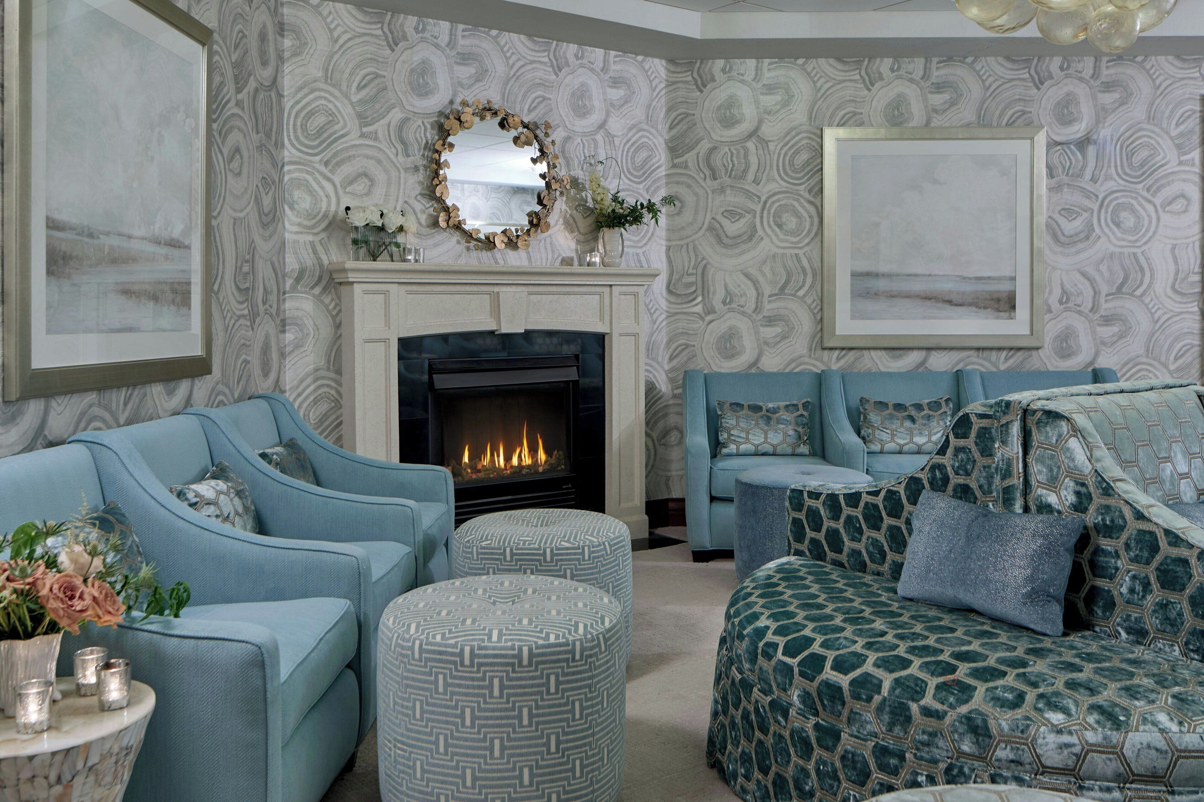 A living room with a fireplace, two sofas, and a patterned wall.