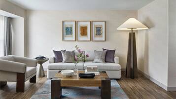 A modern living room with a sofa, armchair, coffee table, and a floor lamp.