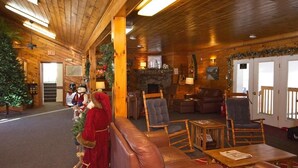 A cozy lodge interior with wooden walls, leather seating, and a fireplace. - River View Resort (Bethel)