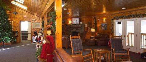 A cozy lodge interior with wooden walls, leather seating, and a fireplace.