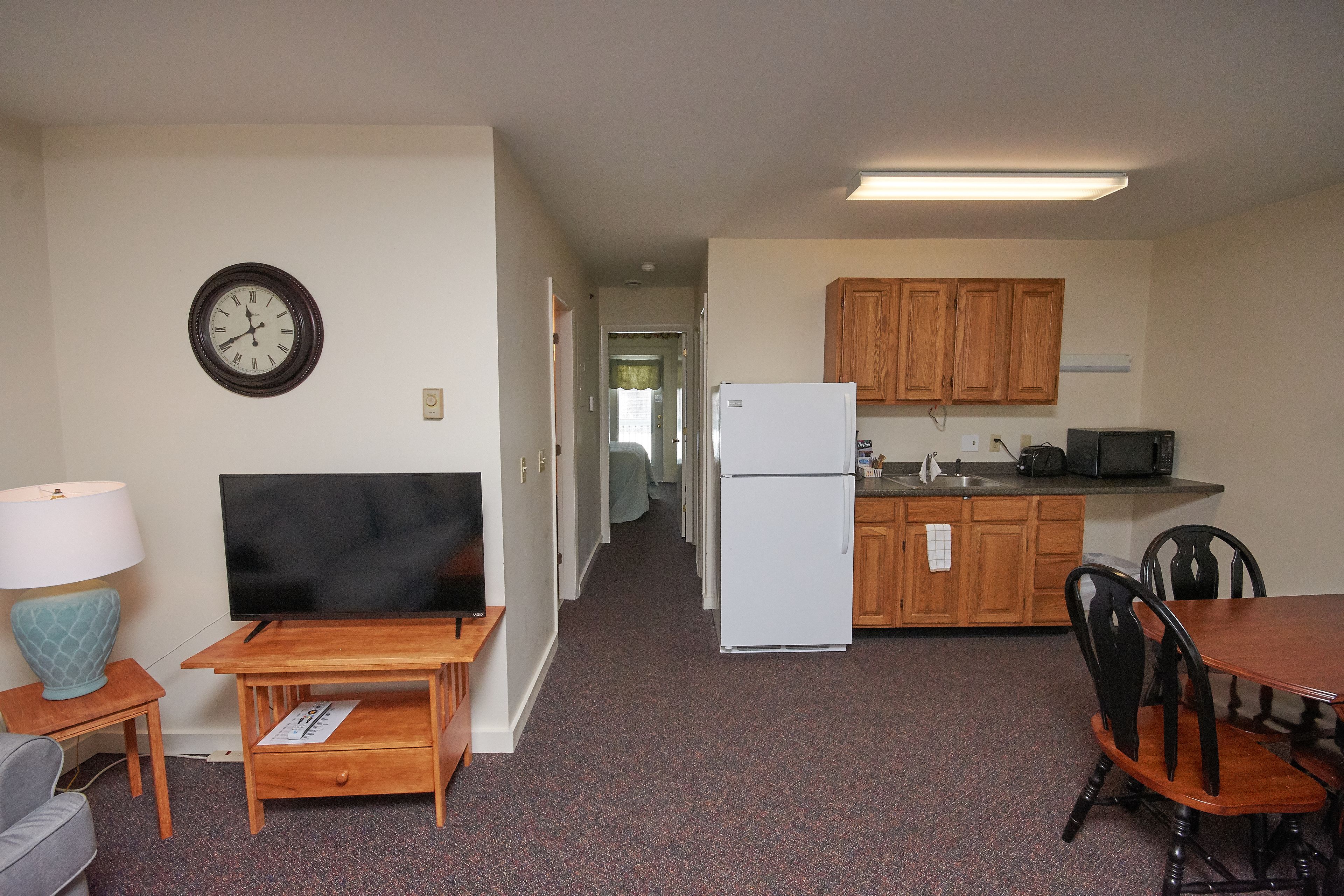 A compact living space with a kitchenette, a dining area, and a TV.