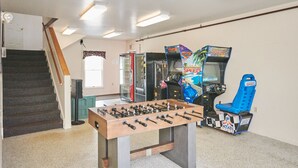 A room with a foosball table, a staircase, and arcade games including a 'Speed' game. - River View Resort (Bethel)