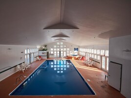 Una piscina techada, sillones reclinables de piscina