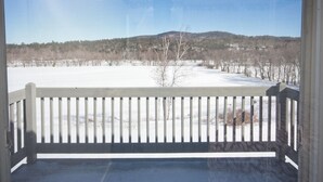 A balcony with a view of a snowy landscape and hills. - River View Resort (Bethel)