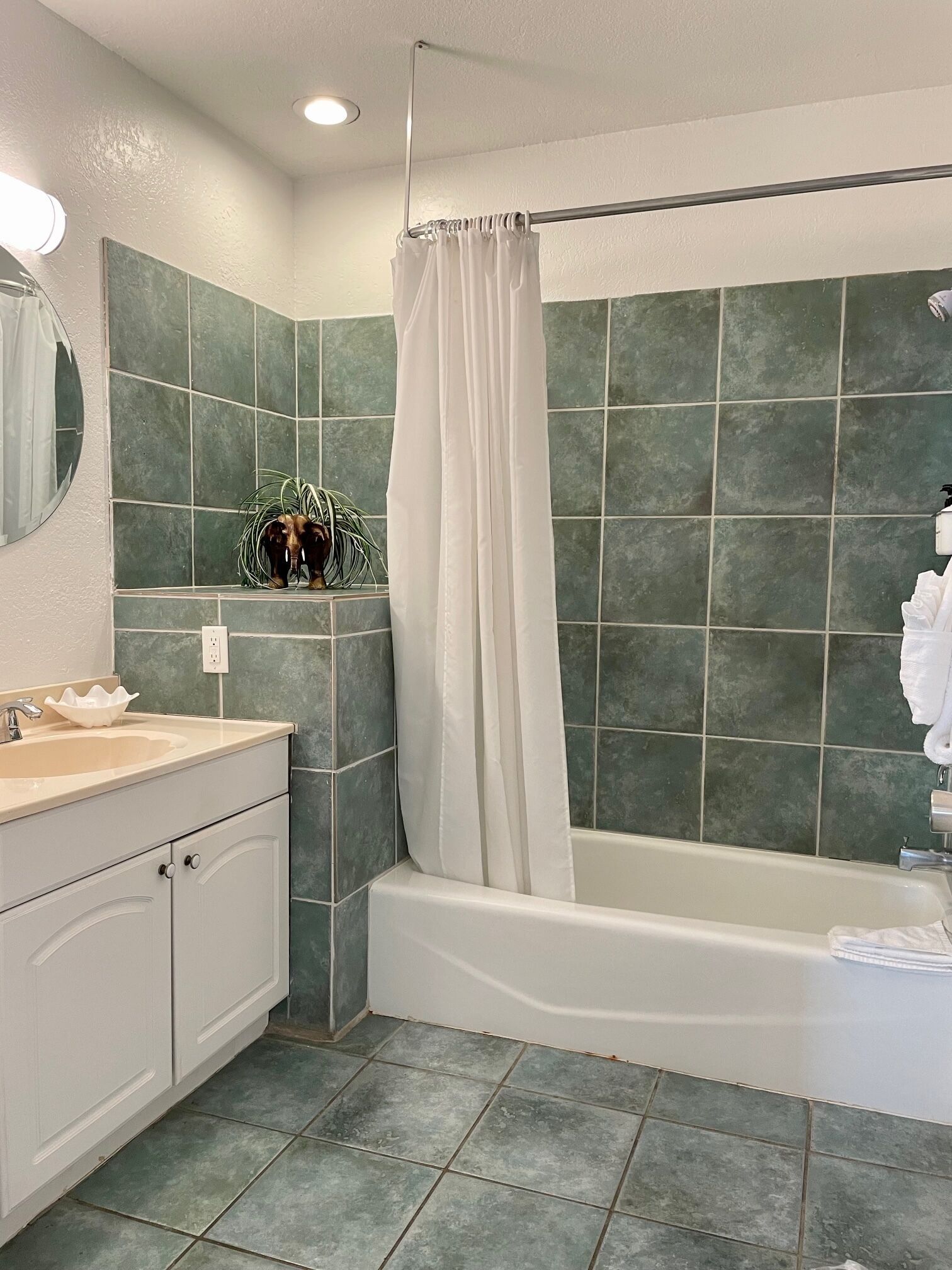 Un baño con bañera, lavamanos y espejo.