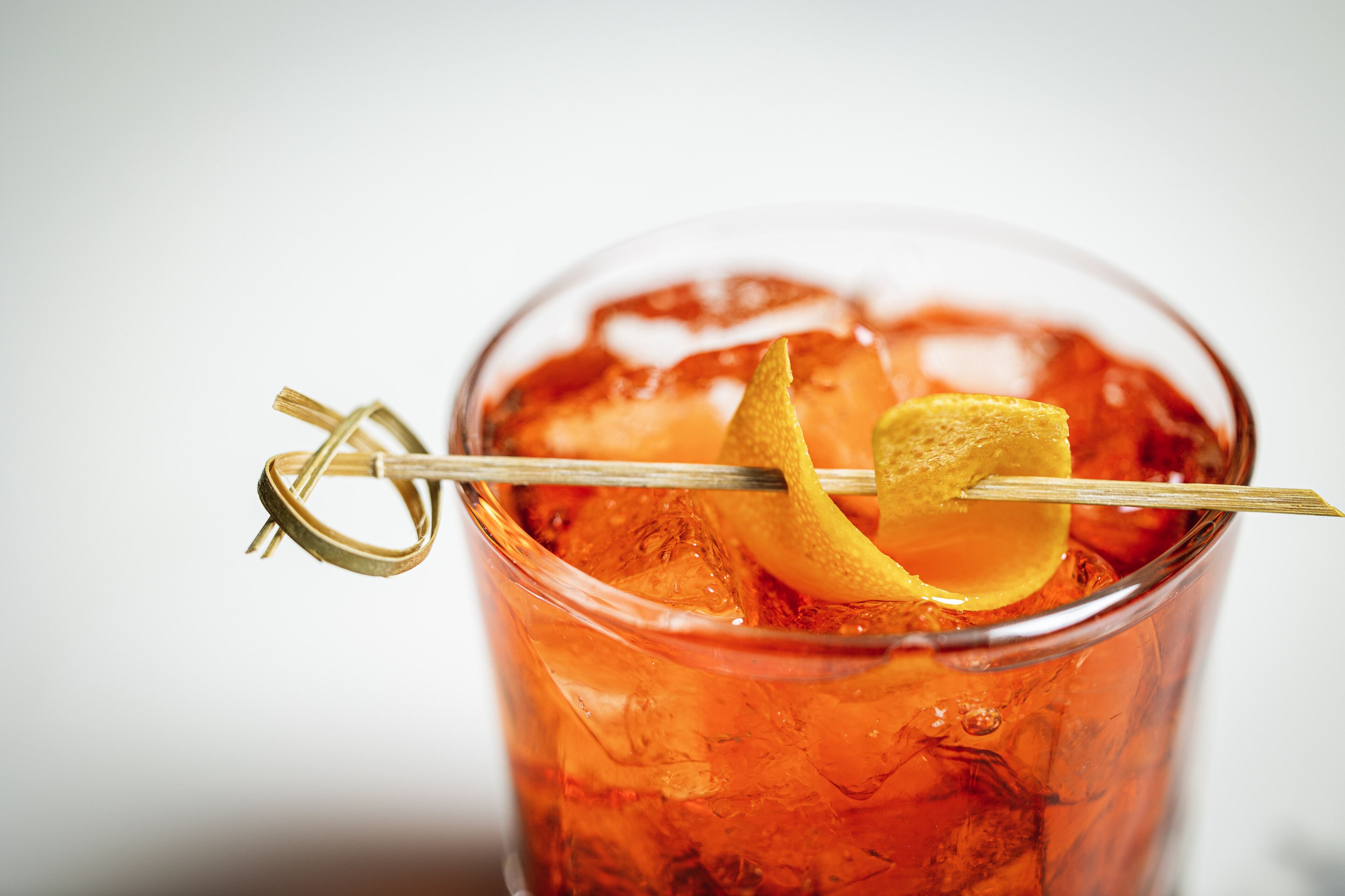 Un cocktail décoré d’une tranche de citron, servi dans un verre rempli de glaçons.