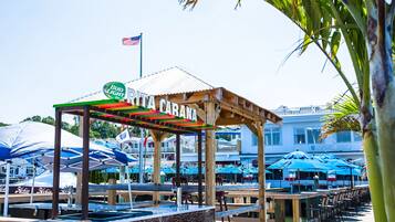A beachside restaurant with outdoor seating and a sign reading "Rita Carana."